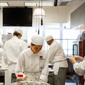 Culinary students in New York City preparing a dish