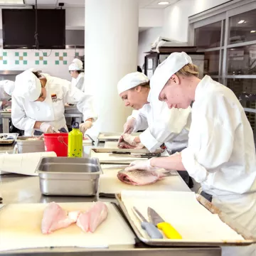 culinary students learning how to fabricate fish