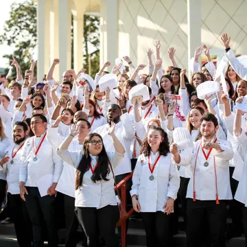 A group of students smile at the ICE Los Angeles 2023 Commencement ceremony