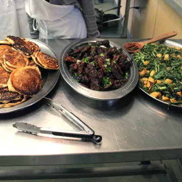 Vegan pancakes, seitan strips and dandelion greens with potatoes.