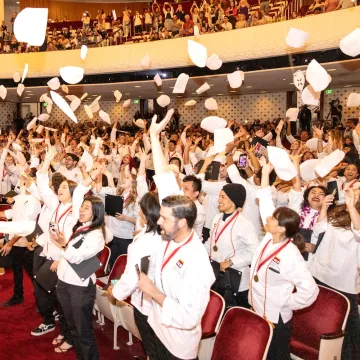 Graduates at the ICE LA 2023 commencement ceremony throw their toques in the air in celebration