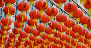 Rows of red lanterns hang suspended from wooden support beams