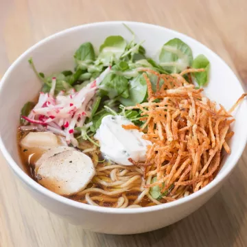 Ramen in a white bowl on a wooden table