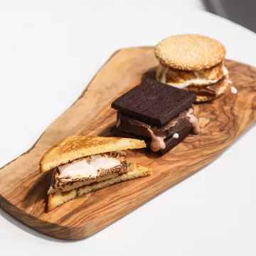 Three s'mores on wooden board