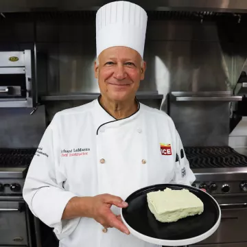 Chef Richard holding a plate with a block of tofu on it