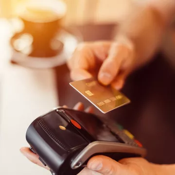 A hand readies a credit card for a transaction.