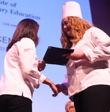 An ICE student receives a diploma at commencement