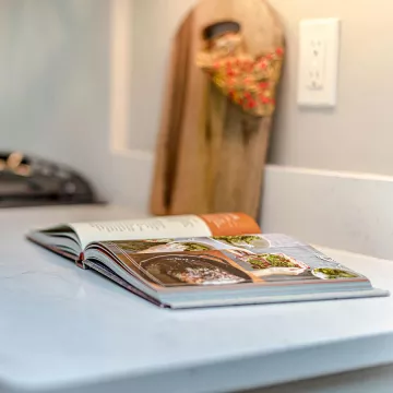 An open cookbook on a kitchen counter.