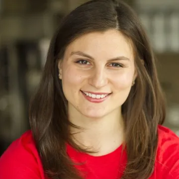 Kerry Brodie, founder of Emma's Torch, wears long, straight brown hair and red top while smiling for camera.