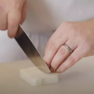 Chef Chris Arturo uses a knife to cut a turnip