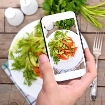 A hand take a photo of a style salad