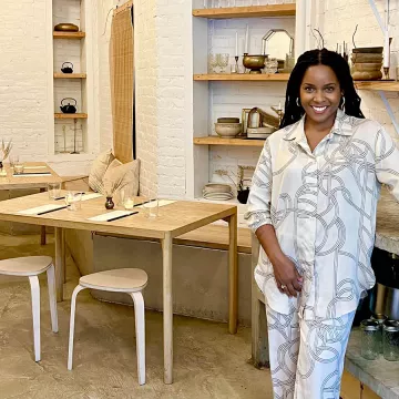 Chef Rasheeda Purdie stands in front of a wooden table