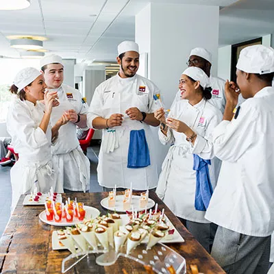 Culinary Class gathering around table of canapes.