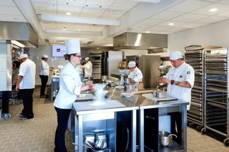 Pastry students and chef instructors in a pastry kitchen at the Institute of Culinary Education