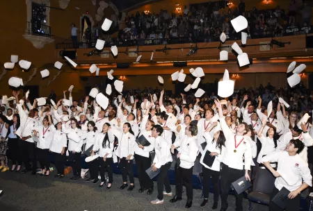The first classes of graduates from ICE's Los Angeles campus toss their toques at the inaugural commencement.