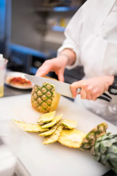 Chef Barb cuts a pineapple
