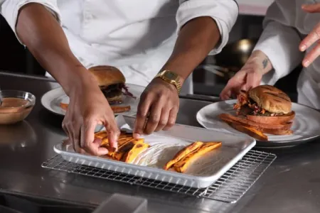 students from ICE's Culinary Nutrition course plate sweet potato fries alongside a burger