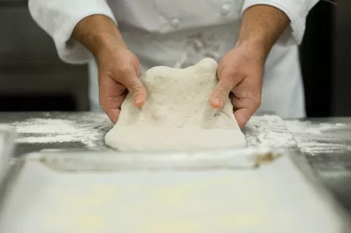 A student kneads dough in class in the Artisan Bread Baking program at the Institute of Culinary Education