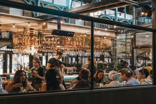 photo of a busy restaurant taken from outside through a full glass wall of windows