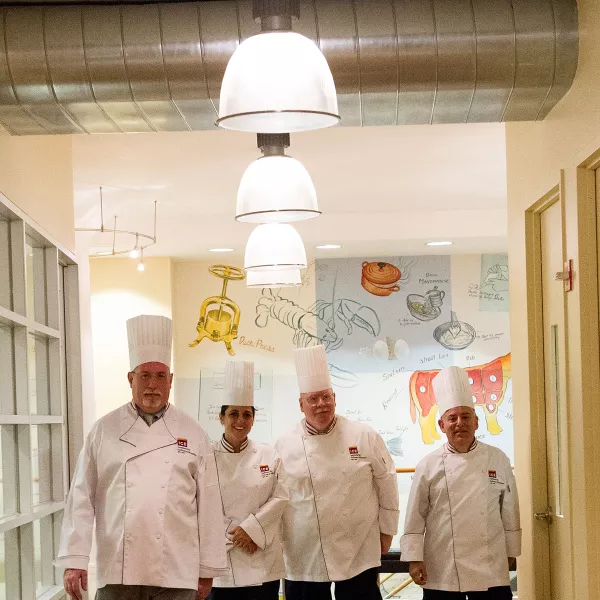 Chef-Instructors walking through halls of ICE LA Campus.