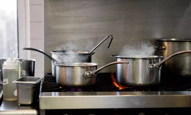 Pots and pans steaming on a professional kitchen stove at the Institute of Culinary Education