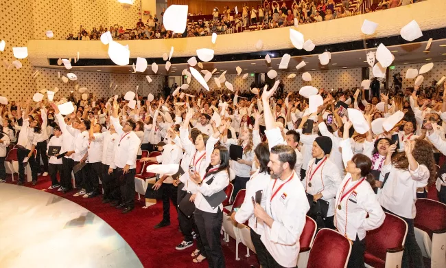 Culinary Arts & Food Operations students toss their toques into the air at ICE graduation