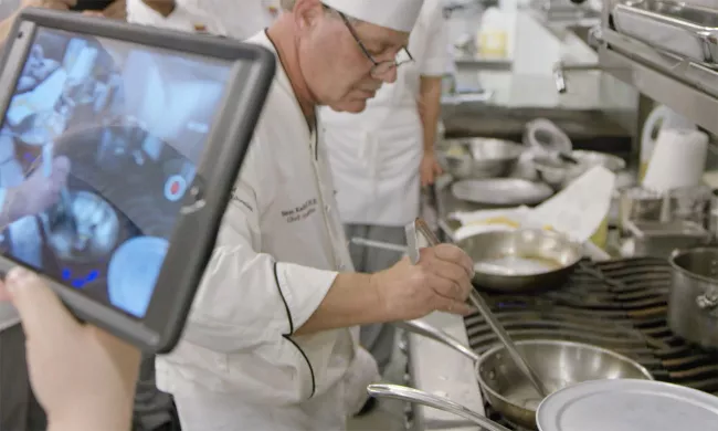An ICE student films a cooking demo in class at the Institute of Culinary Education