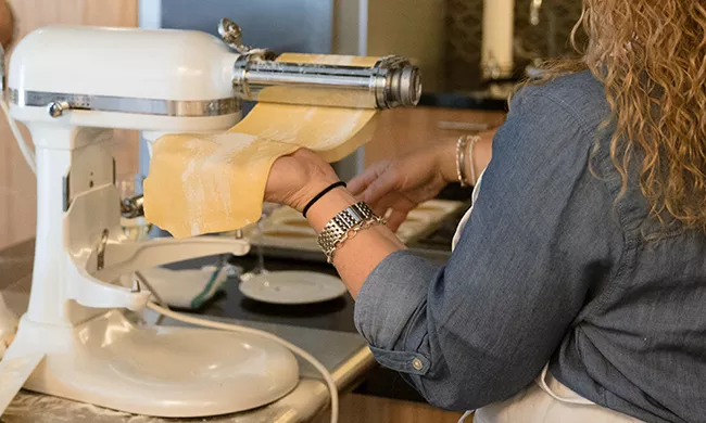 A guest of an ICE special event makes her own pasta dough.