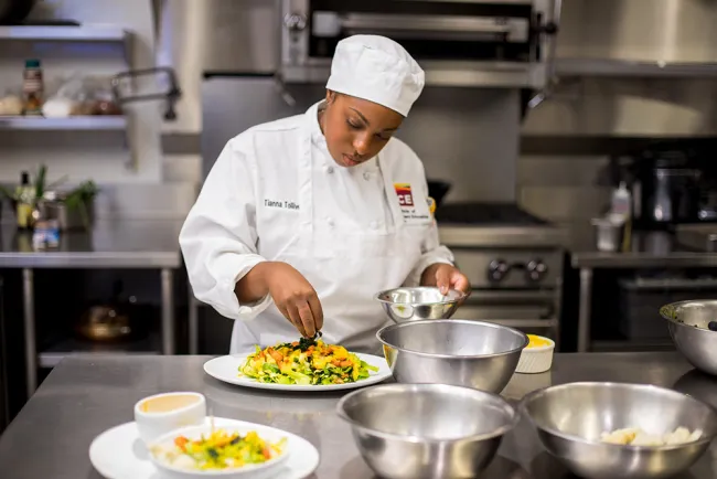 Student plating a heath-supportive meal