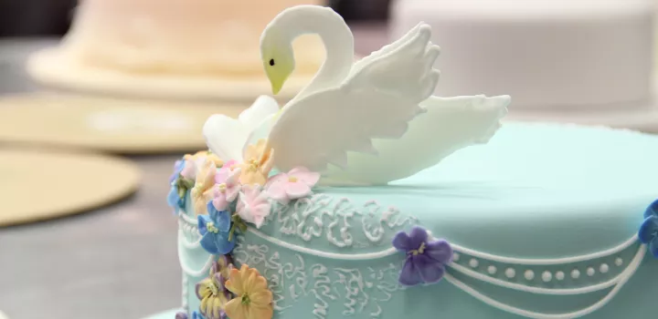 cake professionally decorated with a swan on top