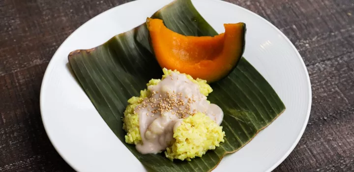 Kabocha squash wedge on a plate with coconut sticky rice