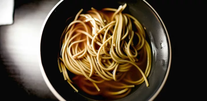 Noodles in a dashi broth in a black bowl