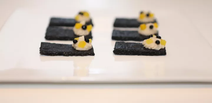 Balsamic Vinegar of Modena pearls with white bean puree and yellow beets on charcoal crackers.