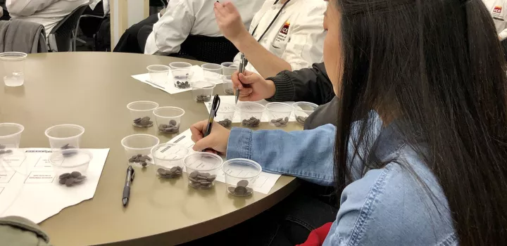 Students take notes on chocolate samples during a Barry Callebaut demo.