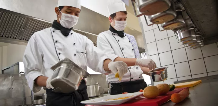 Chefs prepare food with face coverings and gloves