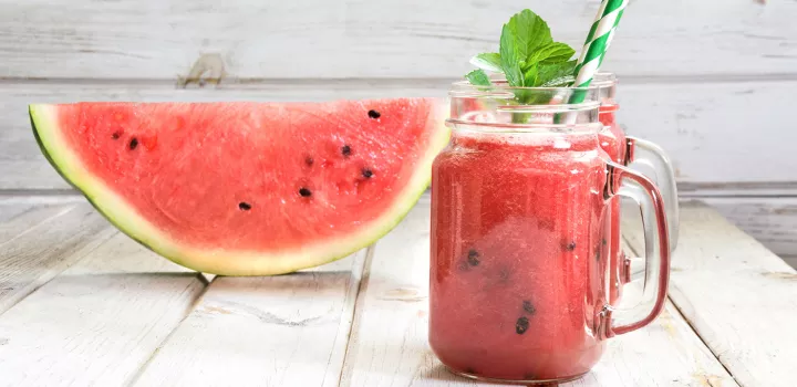 Jars of watermelon juice by a watermelon slice