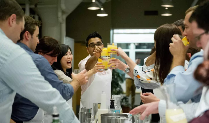 Guests toasting with cocktails at a mixology party at the Institute of Culinary Education