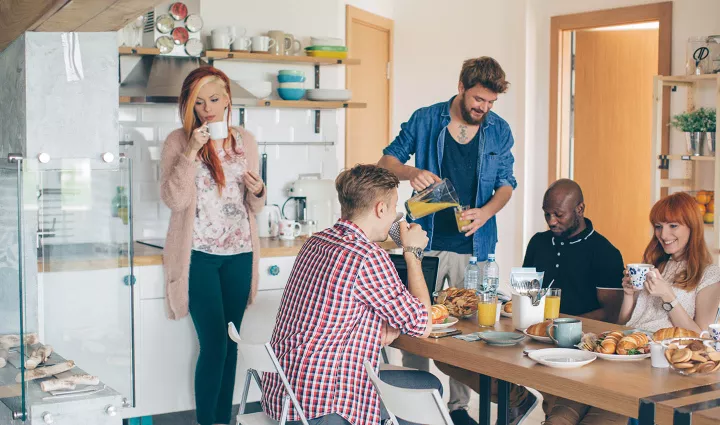 People have breakfast in a common area in a co-living space.