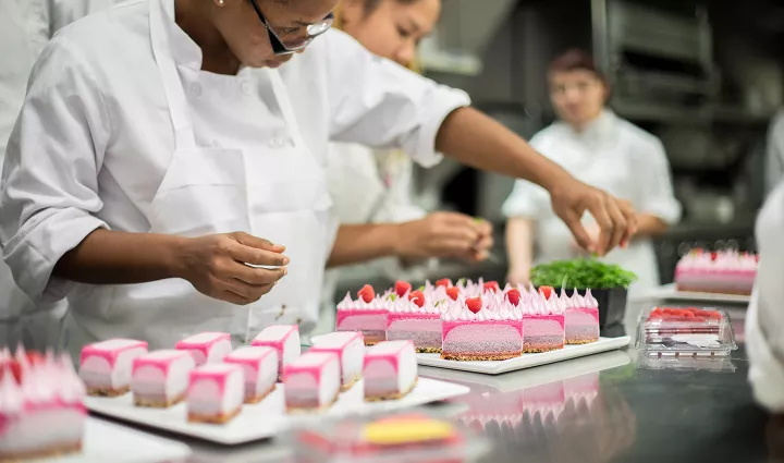 An advanced pastry student puts the finishing touches on entremets at the Institute of Culinary Education