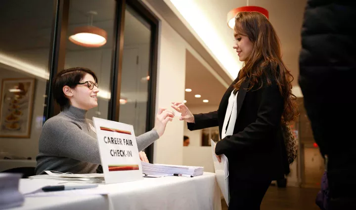 An ICE career services advisor checks in an ICE student for the bi-annual career fair
